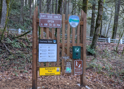 Sign at Oregon State Park entrance, detailing hours, rules, and safety information for day use visitors.
