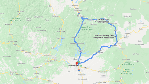 Map showing a route from Redding to McArthur-Burney Falls, highlighting nearby national forests and trails.