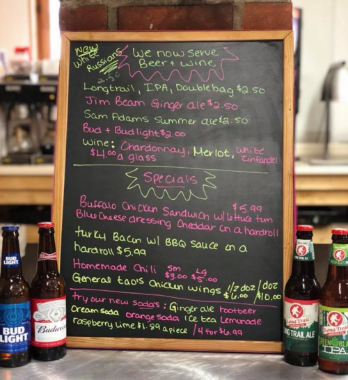 Menu board featuring beer, wine, and food specials like Buffalo chicken sandwich and homemade chili. Prices listed.