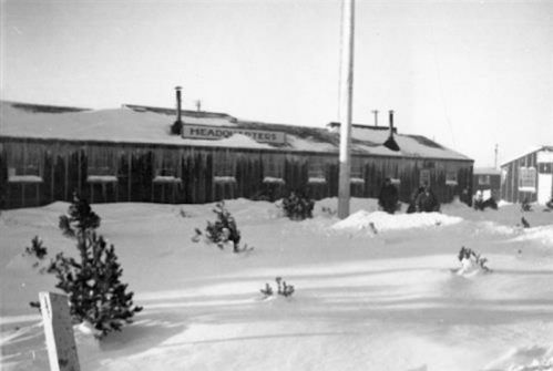 Historic black-and-white photo of a snow-covered building labeled "Headquarters" with people and trees in the foreground.