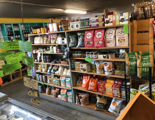 A colorful display of various packaged food items on shelves in a store, including snacks, grains, and cooking ingredients.