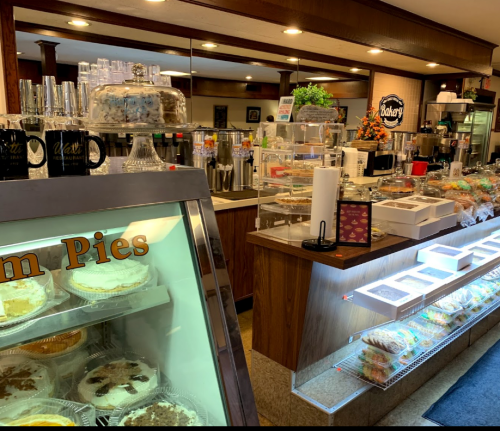 A cozy bakery display featuring various desserts, including pies and cakes, with a welcoming atmosphere.