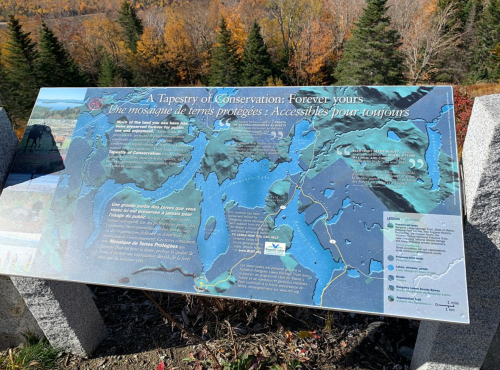 A sign displaying a map titled "A Tapestry of Conservation" with information about protected lands and conservation efforts.