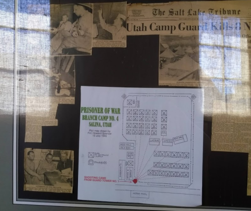 Historical display featuring a newspaper article and a map of a WWII POW camp in Salina, Utah, with photos of camp life.