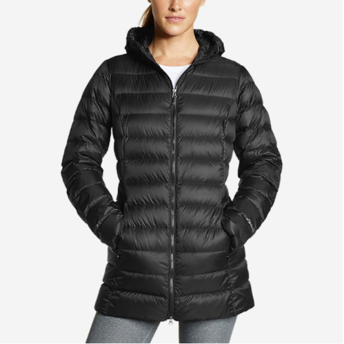 A woman wearing a black puffer jacket with a hood, featuring a zip front and side pockets.