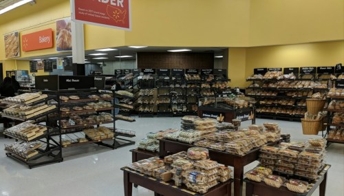 A bakery section filled with various baked goods on display, including cookies, pastries, and bread.