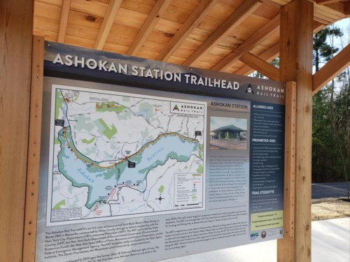 Sign at Ashokan Station Trailhead displaying a map and information about allowed and prohibited uses of the area.