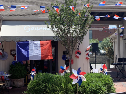 A café decorated with French flags and red, white, and blue bunting for a festive celebration.