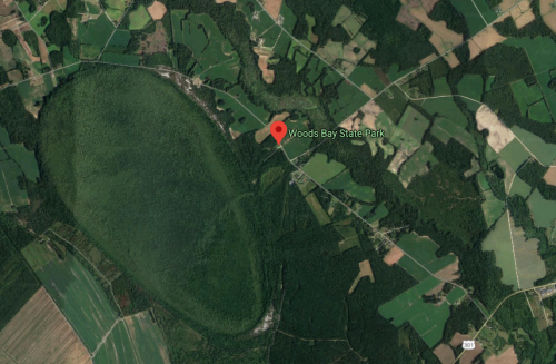 Aerial view of Woods Bay State Park, surrounded by green fields and forests.
