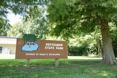 Sign for Pettigrew State Park, featuring trees and the text "Division of Parks & Recreation" in a green landscape.