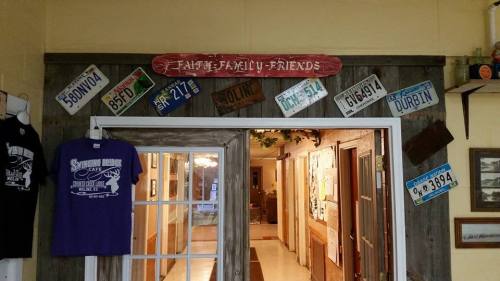 A rustic entrance with a "Family, Family, Friends" sign and various vintage license plates displayed on the walls.