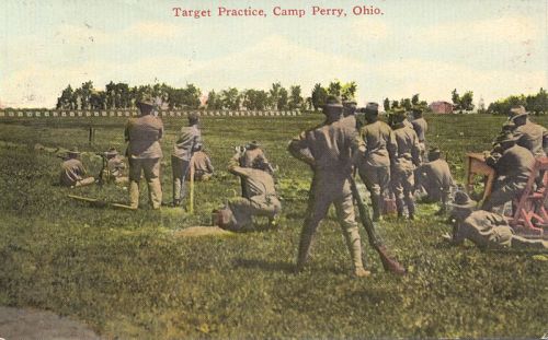 Soldiers practicing target shooting at Camp Perry, Ohio, with a shooting range in the background.