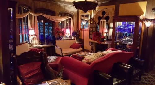 Cozy, vintage-style living room with plush seating, decorative lamps, and ornate decor in warm, inviting colors.