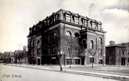 Historic black-and-white photo of a high school building in Blue Island, Illinois, with trees lining the street.
