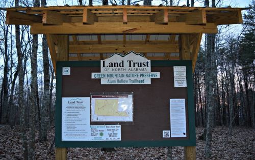 Sign for the Land Trust of North Alabama at Alum Hollow Trailhead, featuring a map and information about the nature preserve.