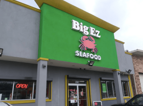 Bright green building with "Big Ez Seafood" sign and a crab logo, featuring an "Open" neon sign in the window.