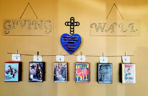 A wall display featuring signs labeled "Giving" and "Wall," with Texas-themed artwork and a heart decoration.