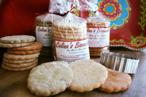 A variety of cookies in packaging, with a cookie cutter and a colorful plate in the background.