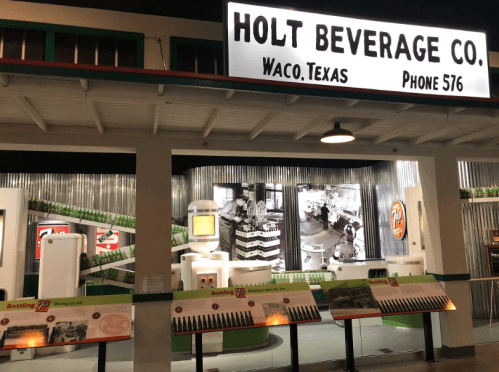 Display of Holt Beverage Co. in Waco, Texas, featuring vintage soda bottles and historical photos.