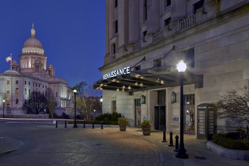 The entrance of the Renaissance hotel at dusk, with a historic dome building in the background.