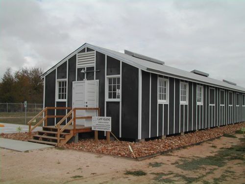 A black and white building with a wooden staircase, surrounded by gravel, featuring a sign that reads "Cap Haven."