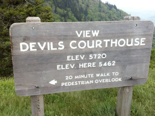 Wooden sign indicating "View Devils Courthouse," with elevation details and directions for a 20-minute walk to an overlook.