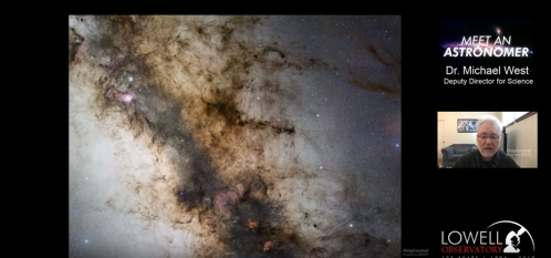 A man speaks in front of a cosmic image featuring stars and dark nebulae, promoting an astronomy event.