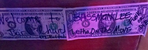 A dollar bill with handwritten messages, including "Welcome to Bassman Lee" and "Let me move."