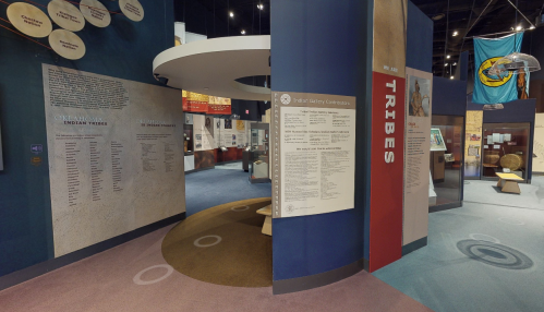 Interior view of a museum exhibit featuring information on Oklahoma Indian tribes and cultural displays.