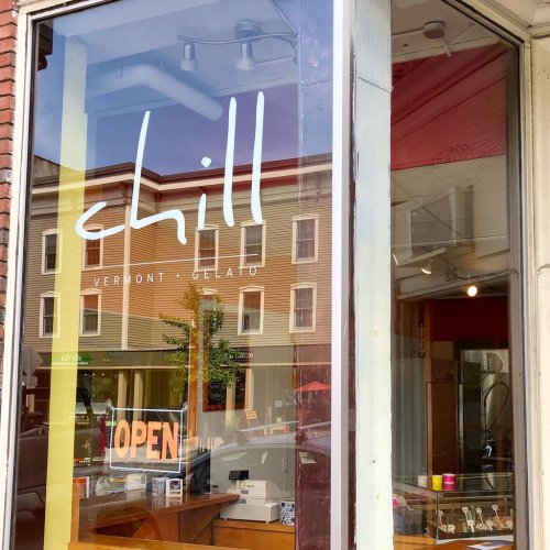 A storefront window with the sign "chill Vermont Gelato" and an "OPEN" sign visible inside.