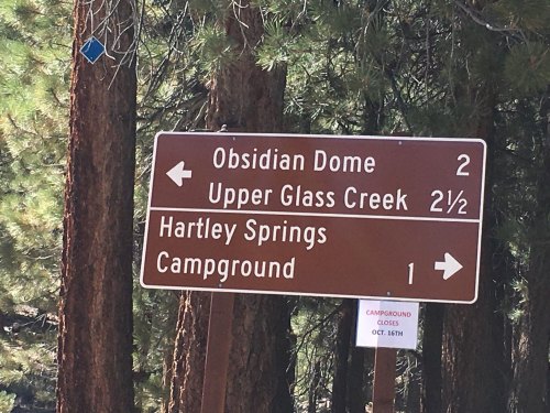 Brown directional sign with distances to Obsidian Dome, Upper Glass Creek, Hartley Springs, and Campground.