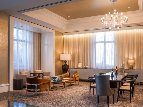 Elegant lounge area with modern furniture, soft lighting, and a stylish chandelier. Warm tones create a cozy atmosphere.