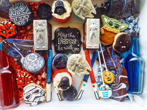A colorful assortment of Star Wars-themed treats, including cookies, cupcakes, and decorations, with "May the Force be with you."