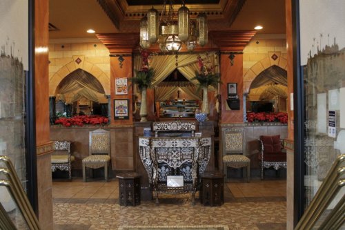 Entrance of a restaurant featuring ornate decor, patterned tiles, and festive red decorations.