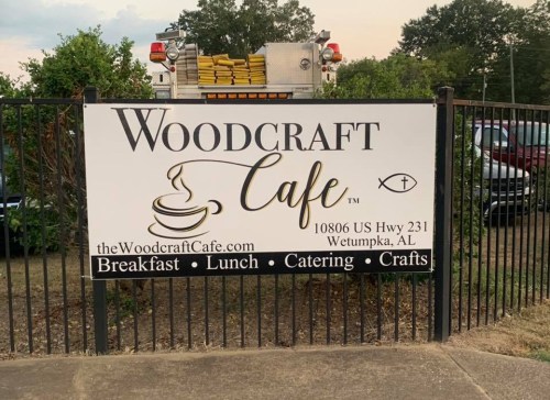 Sign for Woodcraft Cafe in Wetumpka, AL, featuring breakfast, lunch, catering, and crafts.