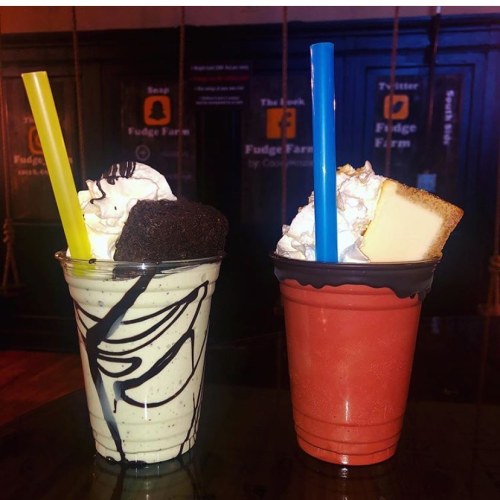Two dessert cups: one with a milkshake topped with whipped cream and a brownie, the other with a cake slice and whipped cream.