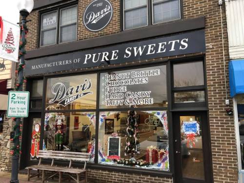Storefront of Dan's Candy Co. featuring a sign for "Pure Sweets" and displays of various candies and treats.