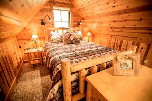 Cozy wooden bedroom with a log bed, plaid bedding, and warm lighting, featuring rustic decor and a family-themed box.