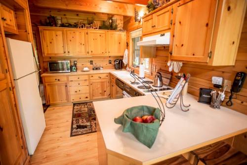 Cozy wooden kitchen with appliances, a countertop basket of apples, and warm, rustic decor.