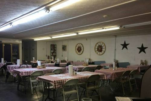 A spacious dining area with checkered tablecloths, chairs, and decorative stars on the walls.
