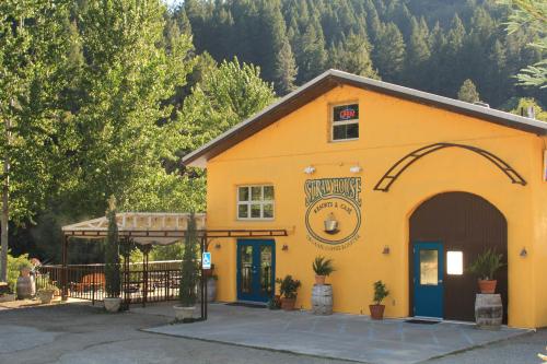 A bright yellow building with a sign reading "Syrup House" surrounded by trees and outdoor seating.