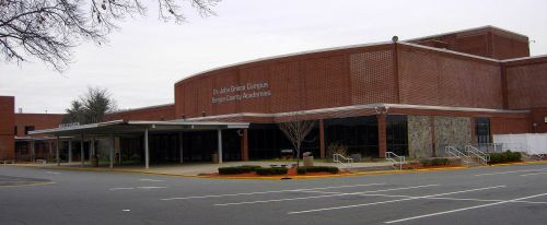 Exterior view of a brick building with a covered entrance, labeled "Dr. John D. Evans Campus, Benton County Academies."