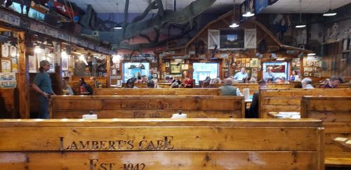 Interior of Lambert's Cafe, featuring wooden booths, rustic decor, and diners enjoying their meals.