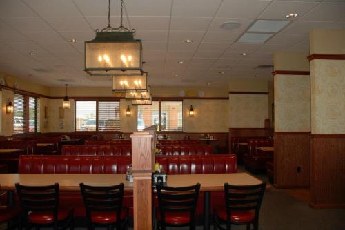 Interior of a restaurant featuring red booths, wooden tables, and warm lighting.