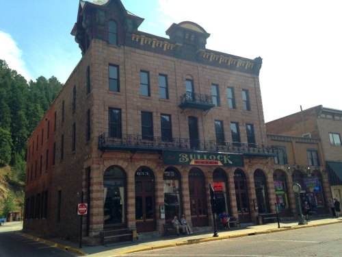 Historic Bullock Hotel in Deadwood, South Dakota, featuring ornate architecture and a sunny sky.