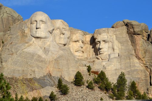 Mount Rushmore featuring the carved faces of four U.S. presidents against a clear blue sky.