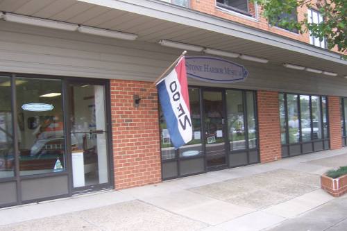 A storefront with large windows and a flag displaying "00" outside, located in a brick building.