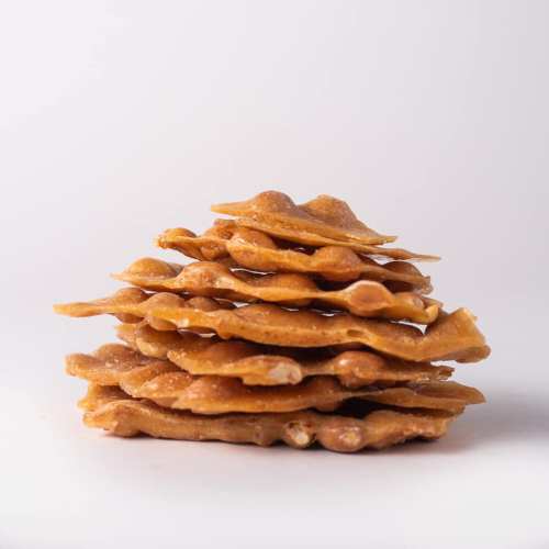 A stack of crispy, golden-brown wafers arranged neatly against a white background.