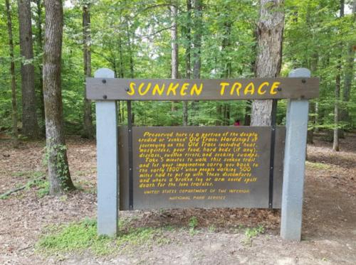 Sign for Sunken Trace, detailing its historical significance and preservation in a wooded area.