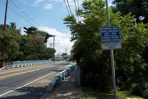 Sign marking the Frankford Bridge on Kings Highway, with Pennypack Creek visible in the background.